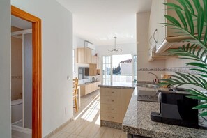 A modern kitchen with a granite countertop, a built-in oven, and a coffee machine. - Edf Papillon (Nerja)