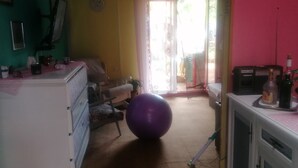 A room with a white dresser, a purple exercise ball, a television, and a pink wall. - Apartment Dario Šolta (Solta)