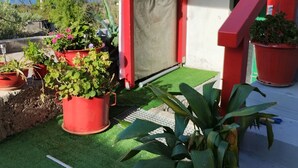 A rooftop garden with potted plants, a red staircase, and a view of the mountains. - Apartment Dario Šolta (Solta)