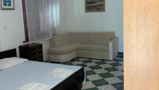A bedroom with a bed, a sofa, a dresser, and a painting on the wall. - Apartments Ata (Razanac)