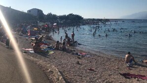 A beach with people swimming and sunbathing. - Apartments Ata (Razanac)