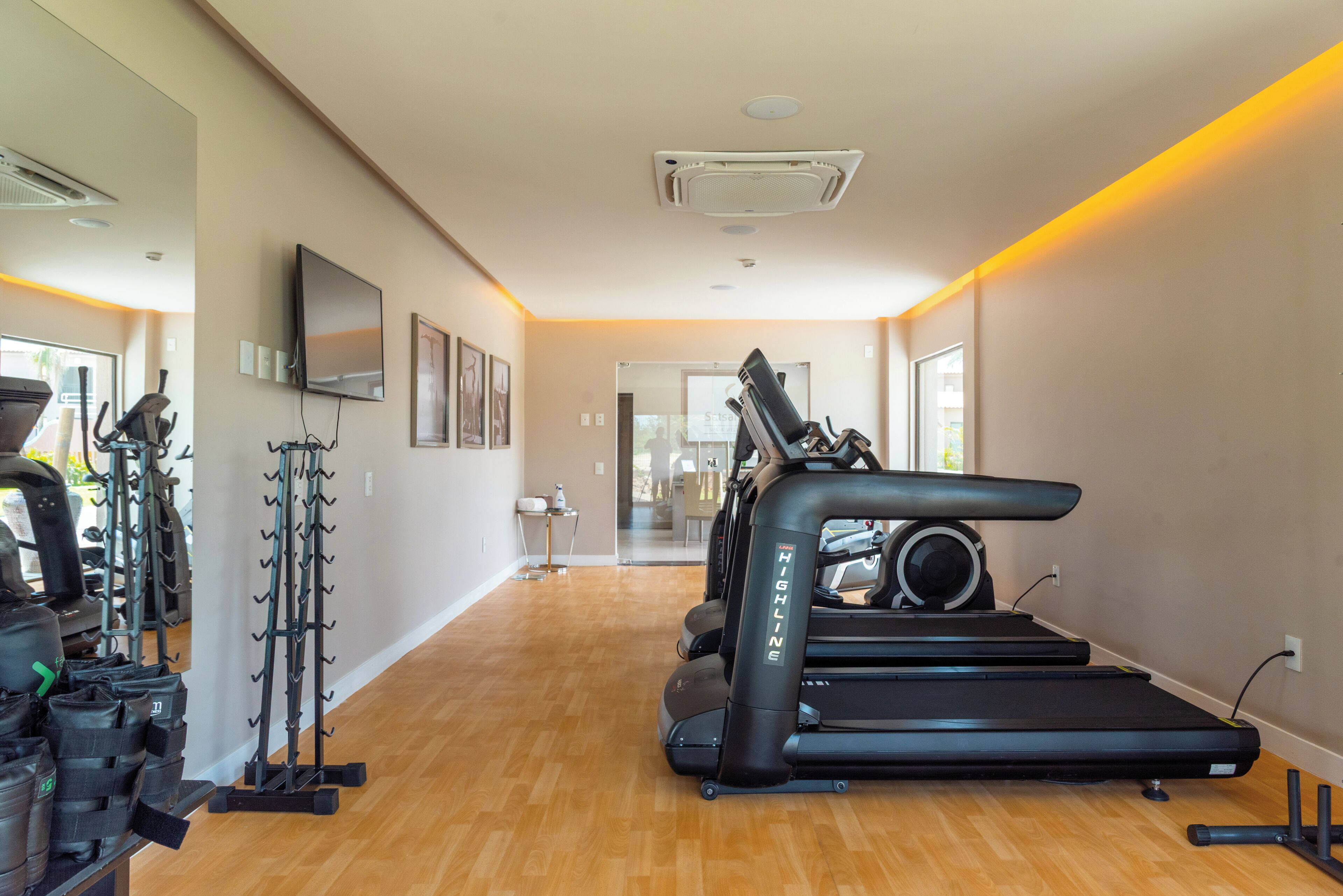 Un gimnasio con cintas de correr, bicicletas estáticas y máquinas de pesas.