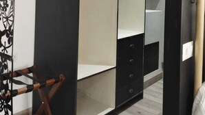 Ein moderner Kleiderschrank mit Spiegel und Ablagefläche, darin ein Holzanzhänger.
