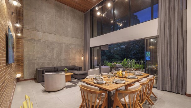 A spacious dining area with a large table set for six, surrounded by wooden chairs.