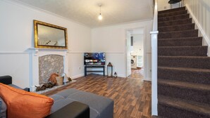 A living room with a fireplace, a staircase, and a television. - 2 Bed-sleeps 4-private Garden- Free Parking (Birmingham)