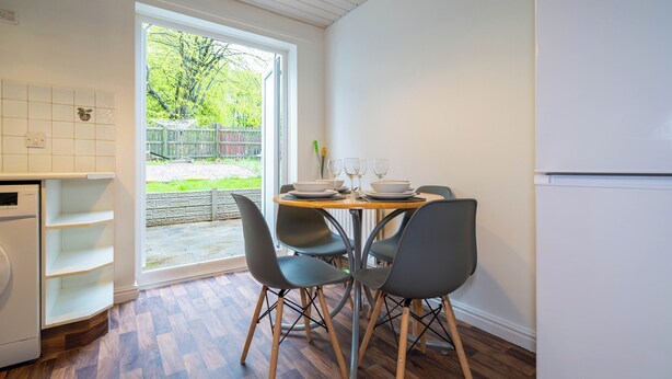 A kitchen with a dining table, chairs, and a refrigerator. - 2 Bed-sleeps 4-private Garden- Free Parking (Birmingham)
