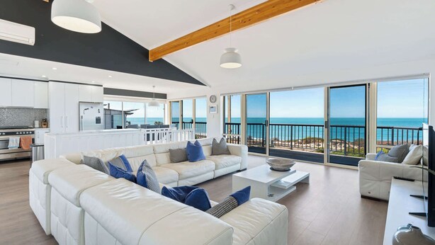 A modern living room with a large white sofa, a coffee table, and a view of the ocean. - Seascape at Boomer 2 Ocean Rd, Port Elliot (Port Elliot)