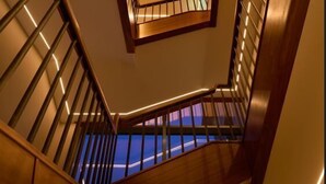 A modern staircase with wooden steps and metal railings, leading to a landing with a skylight. - The James Hotel (Tralee)