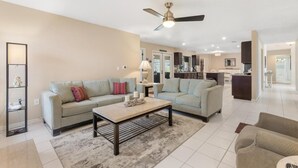 A modern living room with a sofa, coffee table, and a ceiling fan.