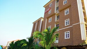 A multi-story hotel building with a brick facade and multiple windows. - ROSES REGENCY HOTEL & SUITES (Abuja)