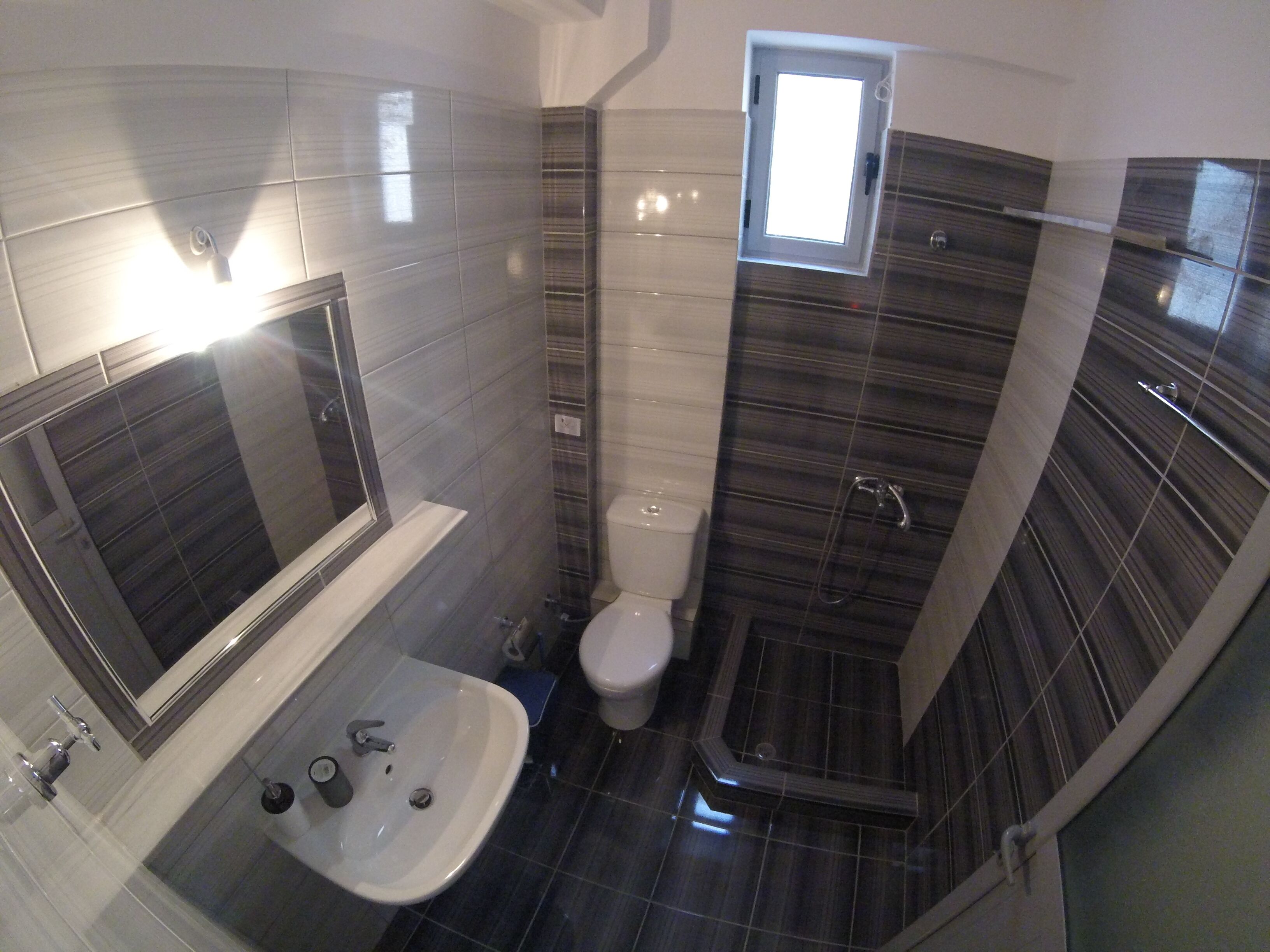 Un baño pequeño con bañera, lavamanos, inodoro y ducha.