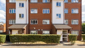 A multi-story residential building with a brick facade, multiple windows, and a gated entrance. - The Bridge Flats (London)