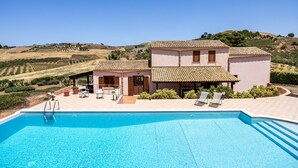 Un bâtiment à deux étages doté d’une piscine, d’un espace extérieur aménagé et offrant une vue sur la campagne.