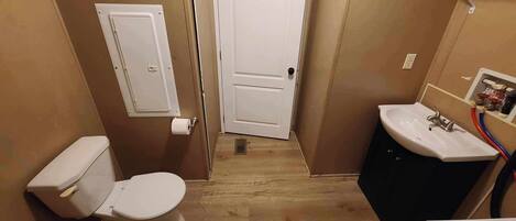 A small bathroom with a toilet, sink, and door.