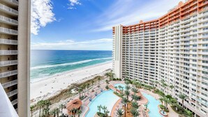 Un hotel moderno con vista al mar, piscina y varios balcones.
