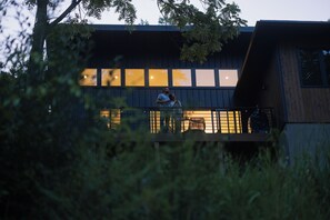 Ein modernes Gebäude mit einem Balkon, der auf einen Garten blickt.