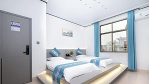 A modern hotel room with two beds, a large window with blue curtains, and a view of buildings outside. - Meizhou Island Beach House Resort Hotel (Putian)