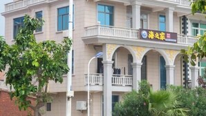 A multi-story building with a balcony and arched windows. - Meizhou Island Beach House Resort Hotel (Putian)