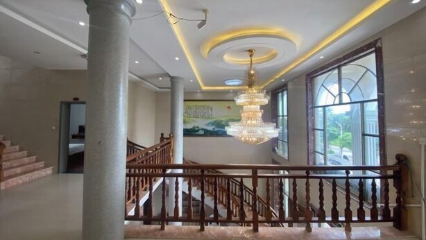 A spacious lobby with a grand chandelier, a staircase with wooden railings, and large windows offering a view of the outdoors. - Meizhou Island Beach House Resort Hotel (Putian)