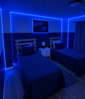 A room with two beds, a nightstand, a lamp, and a wall-mounted picture. - Summer Specials! #1 Location, Arcade, Near SDC, Modern, Panoramic Views, Pools (Branson)