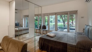 Une chambre moderne avec un grand lit, une cloison en verre et une vue sur l’extérieur.