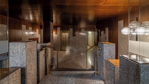 Un intérieur moderne avec des marches en granit, des cloisons en verre et un plafond en bois.
