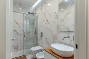 Chuveiro, secador de cabelo, bidê, toalhas de banho