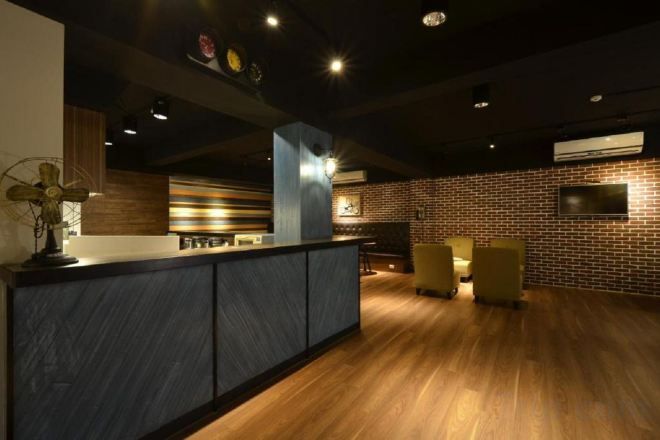 A modern interior with a bar area, seating, and a brick wall.