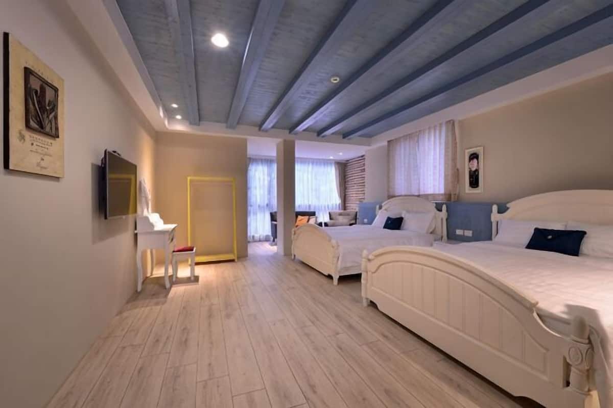 Un dormitorio con dos camas, un escritorio y un televisor.