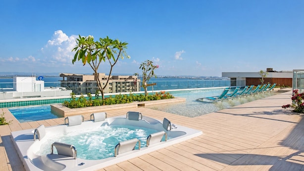 A rooftop pool with a hot tub, lounge chairs, and a view of the sea. -  Balcón + jacuzzi - 2 habitaciones - Exclusivo - Piscina en la azotea (Cartagena)