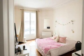 Cozy retreat with a comfortable bed, bedside table, and large window.