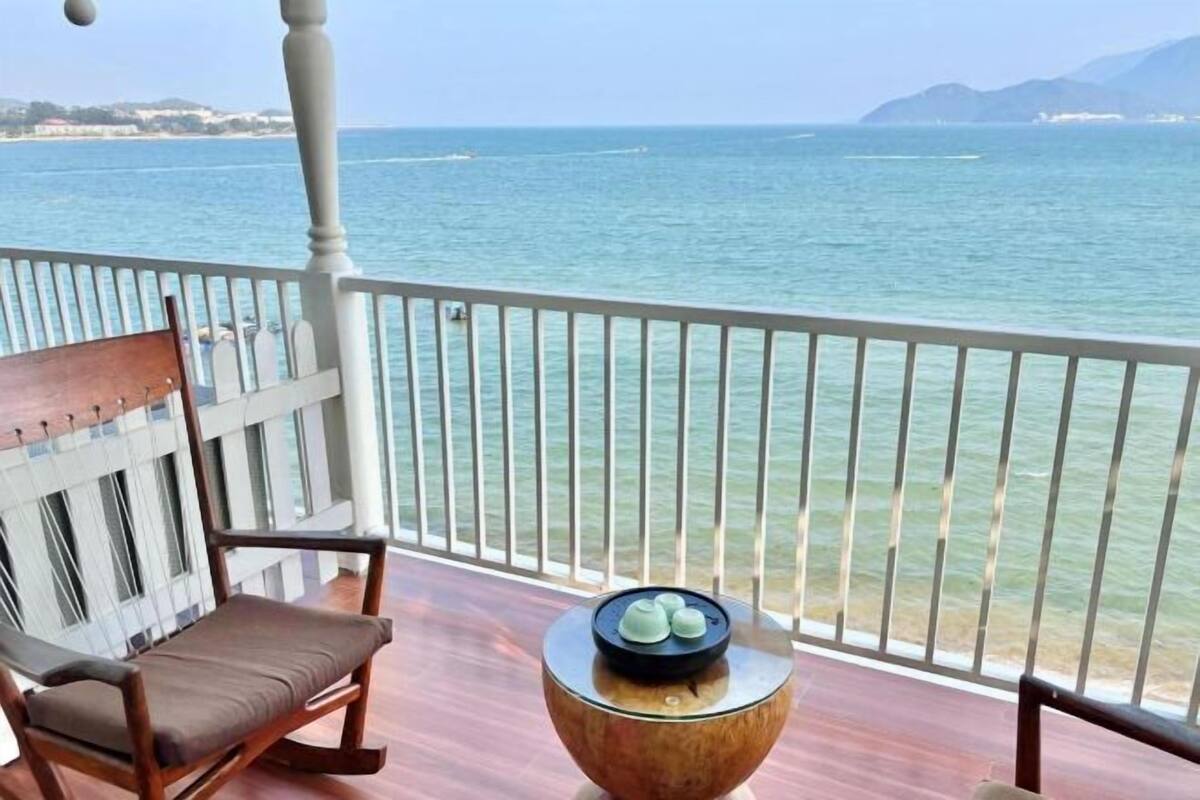A balcony with a wooden chair and a round table with a decorative item.