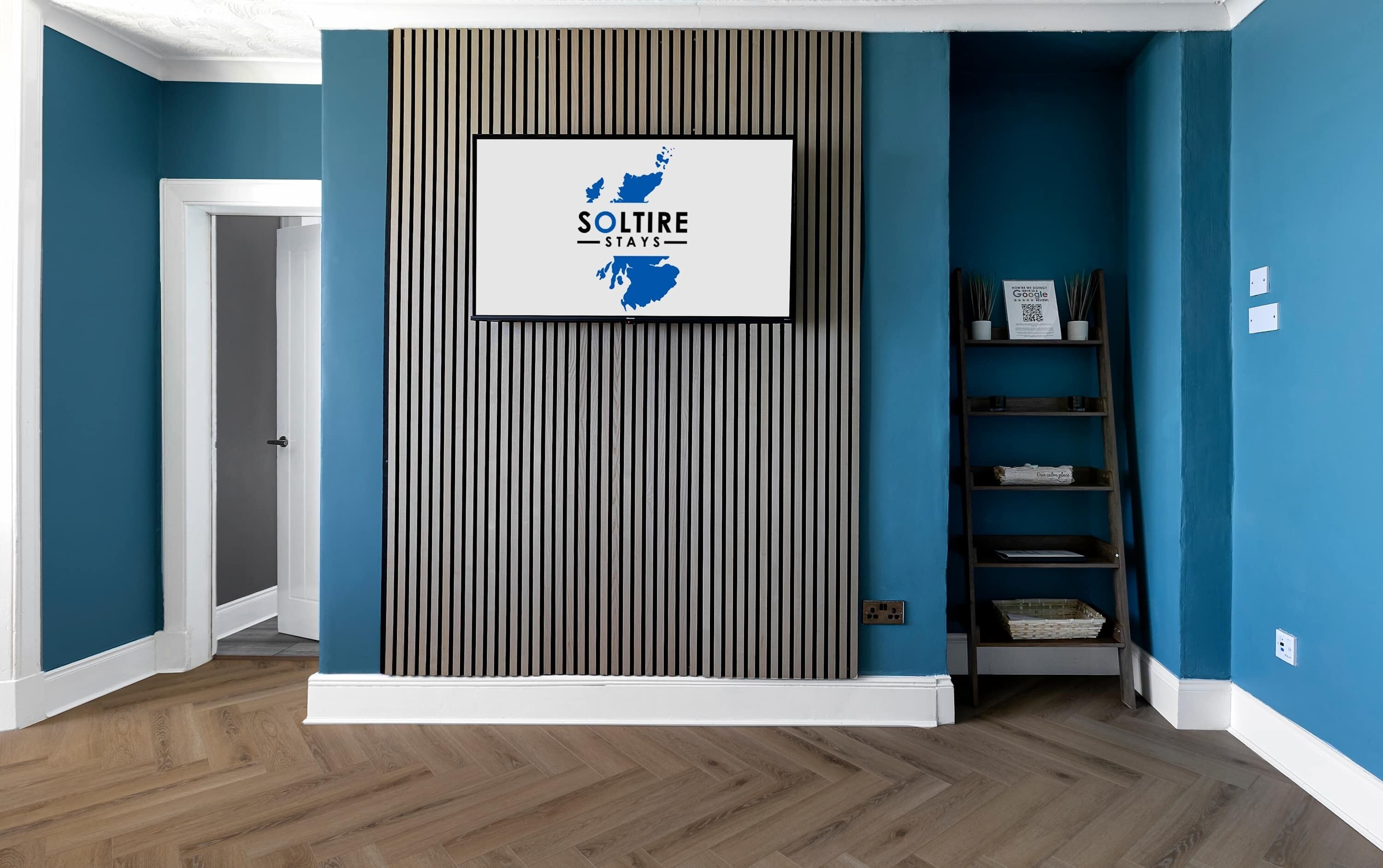 A hallway with a framed sign reading 'SolTire Stays' and a vertical striped wall.