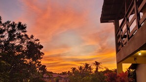 A residential area with a wooden fence, a pathway, and a building with a balcony. - Pousada Oceano Caraiva (Porto Seguro)