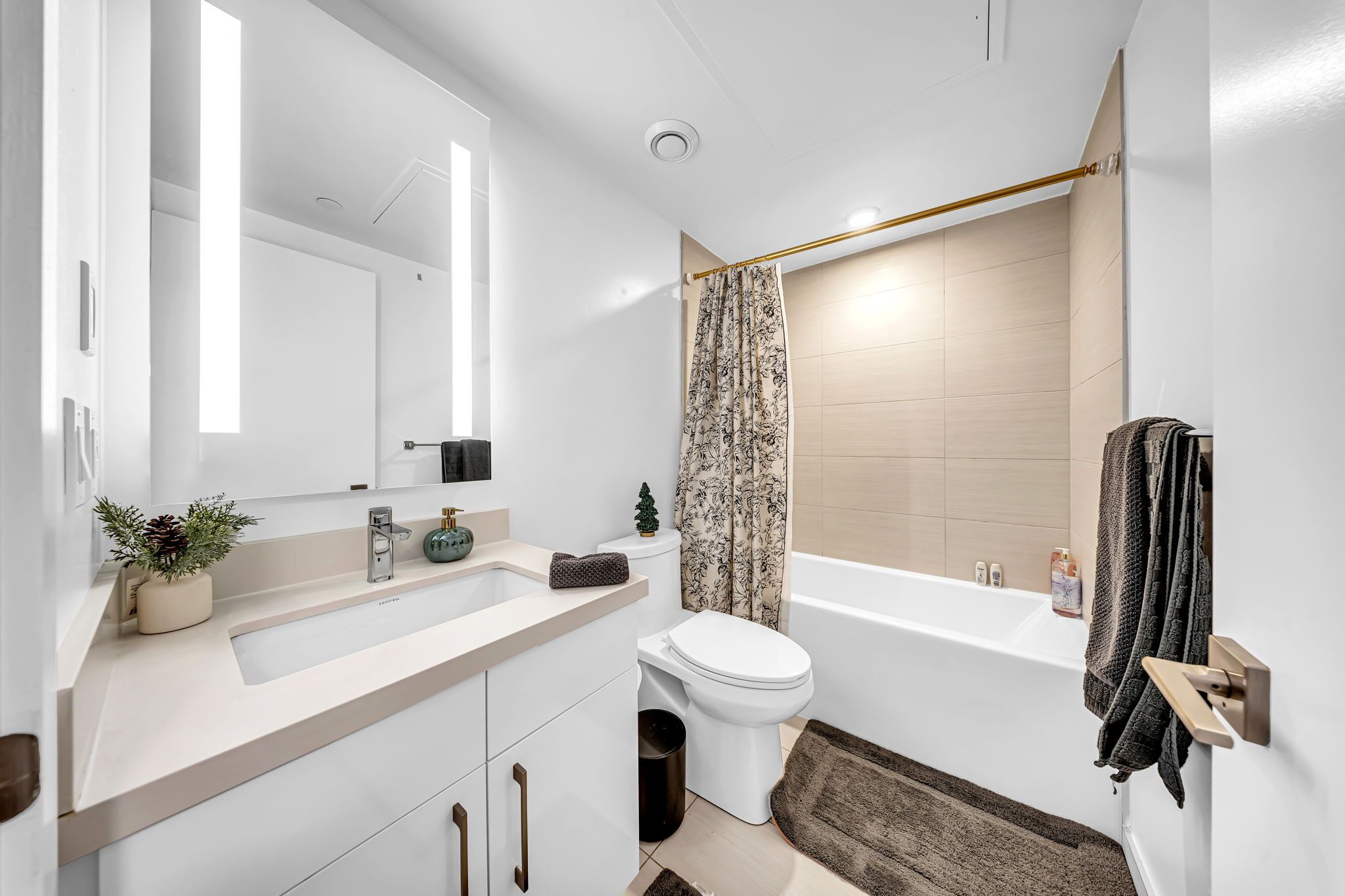 Une salle de bain moderne avec un lavabo, des toilettes et une baignoire, le tout de couleur blanche.