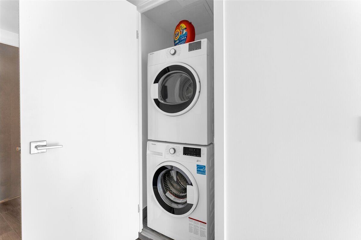 A white wall with a door and a washing machine.