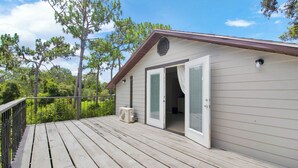 A single-story building with a deck, a sliding glass door, and a small outdoor air conditioning unit. - Cloud 9 -- Cozy studio with WiFi, AC in charming Chuluota, FL (Chuluota)