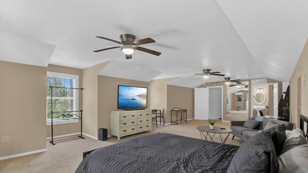 A spacious bedroom with a large bed, a TV, a ceiling fan, and a view of the outdoors. - Cloud 9 -- Cozy studio with WiFi, AC in charming Chuluota, FL (Chuluota)