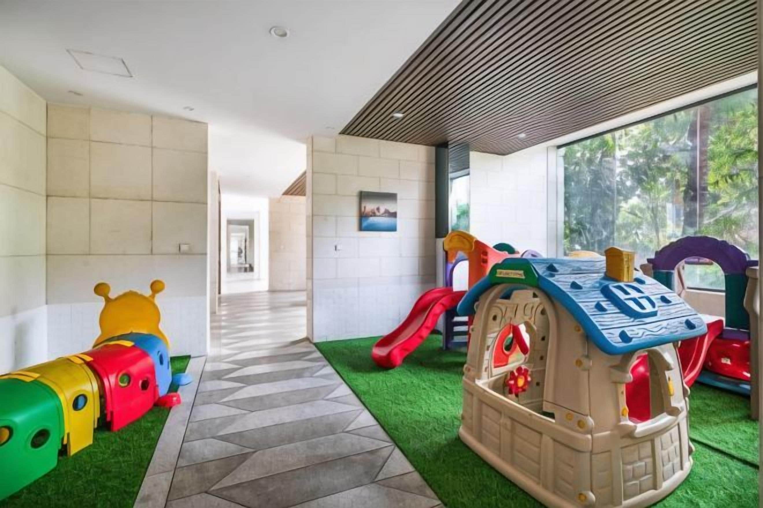A children's play area with a slide, a playhouse, and a train set.