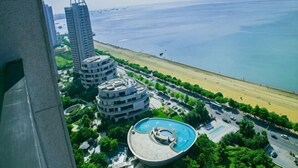 Blick auf die Küste mit modernen Gebäuden, einem Strand und einem kreisförmigen Pool.