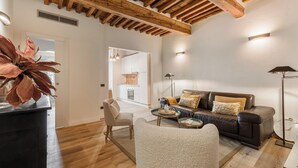 Un soggiorno moderno con soffitto in legno, un divano, una poltrona e un tavolino.