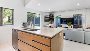 Une cuisine moderne dotée d’un îlot central, d’un lave-vaisselle intégré et d’un coin repas avec une table et des chaises.