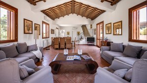 A spacious living area with a high wooden ceiling, a central coffee table, and grey sofas. - Villa sui Colli Ericini con Piscina by Wonderful Italy (Erice)