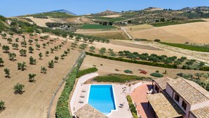 An aerial view of a property with a swimming pool, terraced fields, and a building with a tiled roof. - Villa sui Colli Ericini con Piscina by Wonderful Italy (Erice)