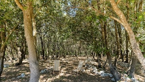 Une zone boisée avec deux chaises en bois et un mur de pierre.