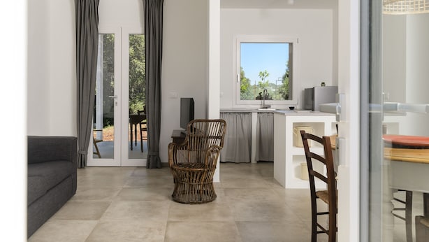 Un espace de vie moderne comprenant un canapé, un fauteuil en osier et une table à manger.