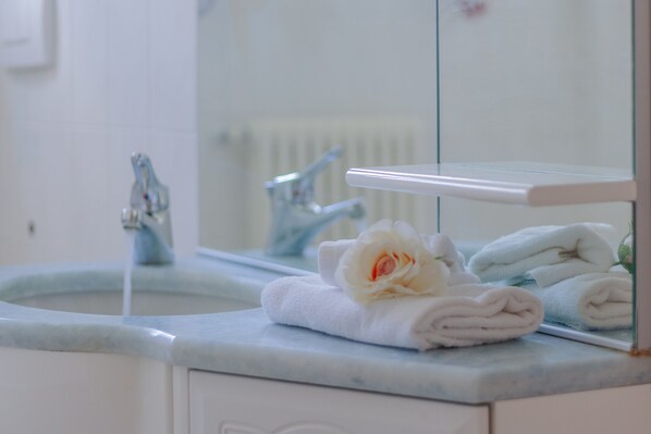 A bathroom with a marble sink, a mirror, and towels. - Sunflowers Home in Mandello del Lario (Mandello del Lario)