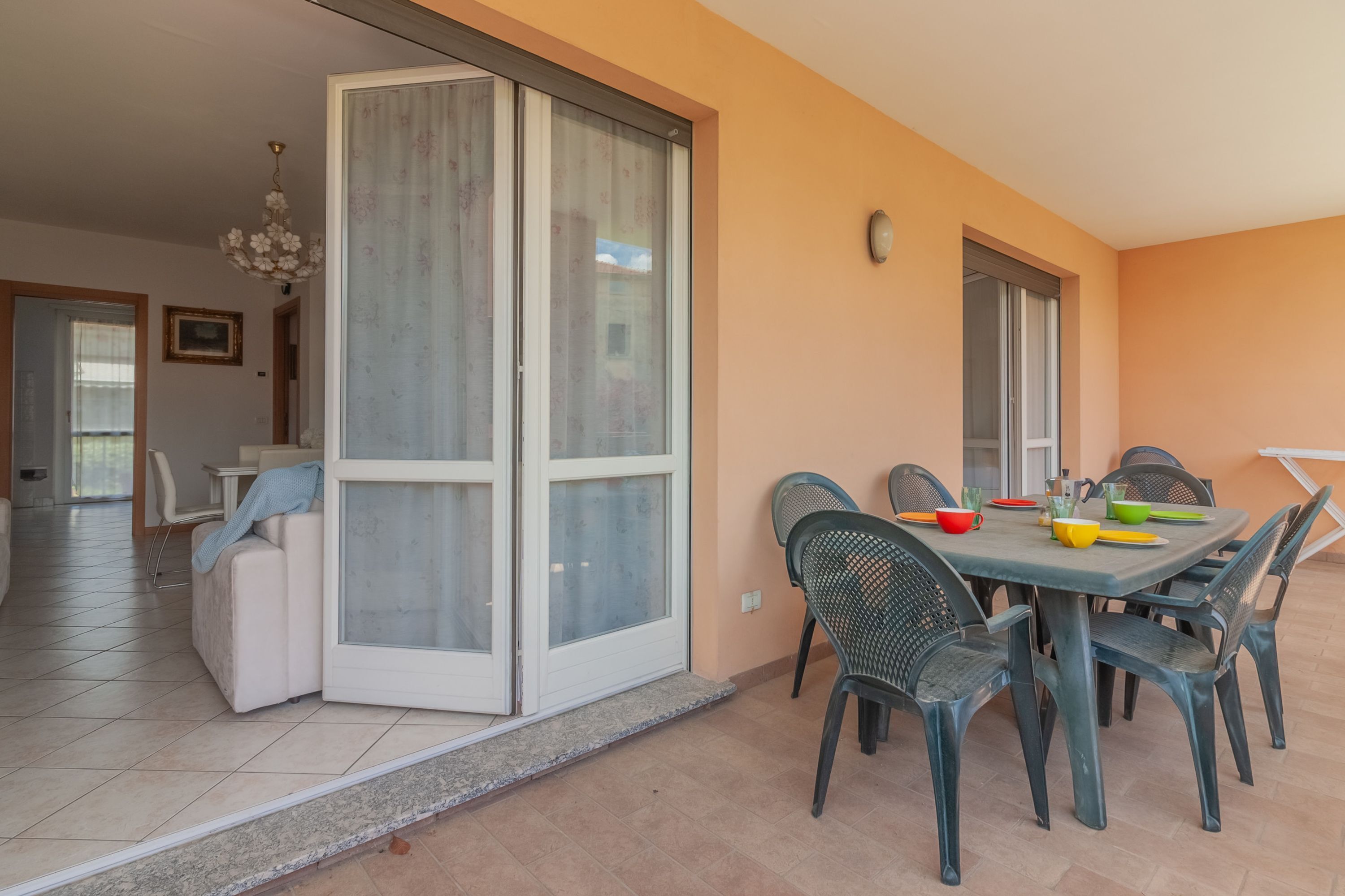 Un espace repas comprenant une table et des chaises, une porte-fenêtre coulissante et une vue sur la pièce adjacente.