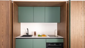 A compact kitchen with green cabinets, a black dishwasher, and a wooden countertop. - Settimo Apartment With Terrace by Wonderful Italy (Palermo)