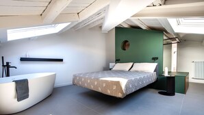 A modern bedroom with a skylight, a large bed, a built-in bathtub, and a green accent wall. - Settimo Apartment With Terrace by Wonderful Italy (Palermo)